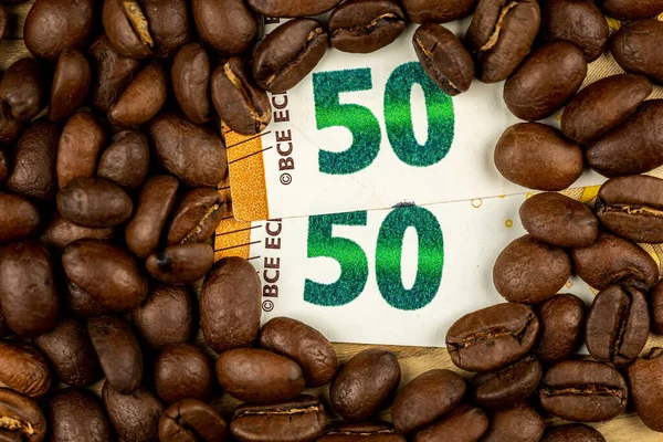 Roasted coffee beans together with 50 euro bill. High price of coffee. Pictute taken in good artificial light.