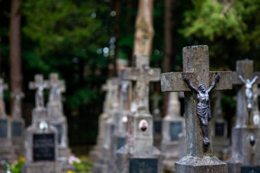 İsa heykelciği mezarlığın çarmıhında. Fotoğraf yumuşak bir ışıkta, gölgeli bir yerde çekildi..