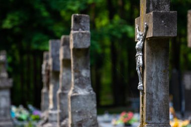 İsa heykelciği mezarlığın çarmıhında. Fotoğraf yumuşak bir ışıkta, gölgeli bir yerde çekildi..