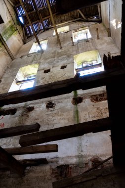 Eski, mahvolmuş bir tahıl değirmeninin içi. Fotoğraf doğal ışık altında çekildi. İklim aydınlatma koşulları.