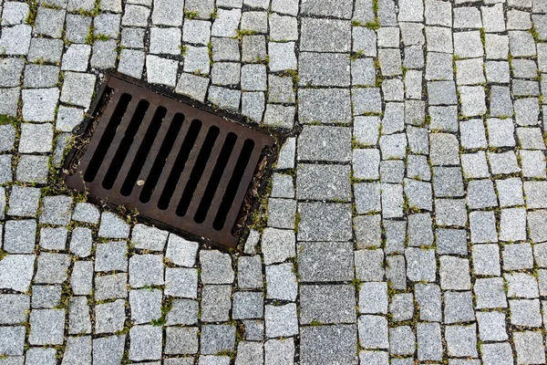 Granit taşla döşenmiş bir caddeye demir atık borusu döşedim. Fotoğraf doğal ışık altında çekildi..