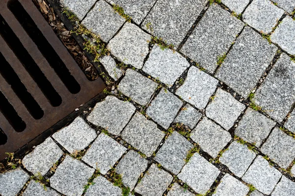 Granit taşla döşenmiş bir caddeye demir atık borusu döşedim. Fotoğraf doğal ışık altında çekildi..