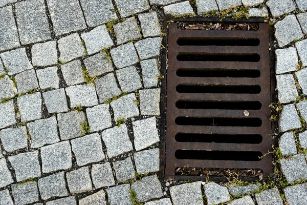 Granit taşla döşenmiş bir caddeye demir atık borusu döşedim. Fotoğraf doğal ışık altında çekildi..