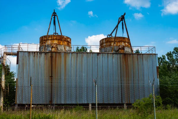 Terk edilmiş bir fabrikada soğutma kuleleri kapatılmış. Fotoğraf, güneşli bir günde çekilmiş..