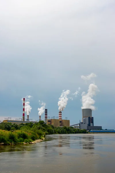 Kozienice 'de kömürle çalışan bir elektrik santrali olan bir panorama. Soğutma kulelerindeki duman ve sigara yığınları. Fotoğraf, bulutlu bir günde doğal ışıkla çekildi..