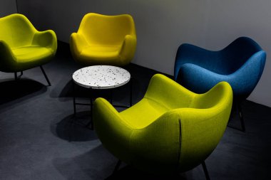 Salgın sırasında boş bir buluşma yeri. Buluşma yerindeki renkli ofis sandalyeleri. insan eksikliği. Atmosferik ve yapay ışıkla aydınlatılmış bir yer..