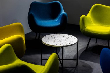 Salgın sırasında boş bir buluşma yeri. Buluşma yerindeki renkli ofis sandalyeleri. insan eksikliği. Atmosferik ve yapay ışıkla aydınlatılmış bir yer..