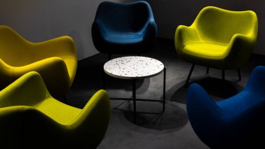 Salgın sırasında boş bir buluşma yeri. Buluşma yerindeki renkli ofis sandalyeleri. insan eksikliği. Atmosferik ve yapay ışıkla aydınlatılmış bir yer..