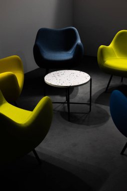 Salgın sırasında boş bir buluşma yeri. Buluşma yerindeki renkli ofis sandalyeleri. insan eksikliği. Atmosferik ve yapay ışıkla aydınlatılmış bir yer..