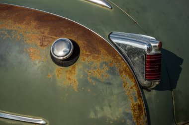 Restorasyondan önce yeşil klasik bir arabanın krom kaplama arka lambası. Fotoğraf doğal ışık altında çekildi..