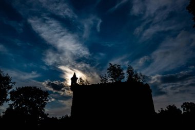 Dramatik bir gökyüzüne karşı gizemli bir şatonun kalıntıları. Fotoğraf öğlen çekildi, gece ay ışığını taklit ederek.