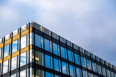 Mavi gökyüzü arka planına karşı modern bir apartmanın cephesi. Fotoğraf, güneşli bir günde öğleden sonra çekildi..