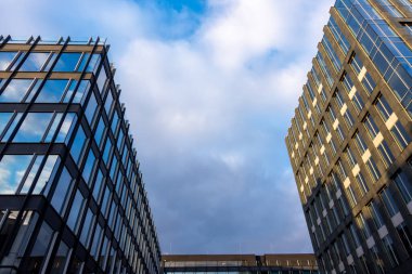 Mavi gökyüzü arka planına karşı modern bir apartmanın cephesi. Fotoğraf, güneşli bir günde öğleden sonra çekildi..