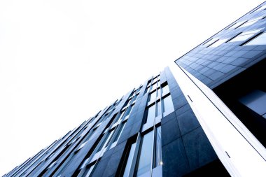 Aşırı yanan gökyüzüne karşı modern bir ofis binası gibi. Fotoğraf, güneşli bir günde öğleden sonra çekildi..