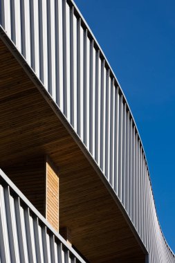 Mavi gökyüzü arka planına karşı modern bir kamu binasının cephesi. Fotoğraf, güneşli bir günde öğle vakti çekildi..