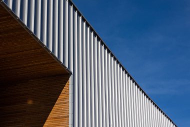 Mavi gökyüzü arka planına karşı modern bir kamu binasının cephesi. Fotoğraf, güneşli bir günde öğle vakti çekildi..