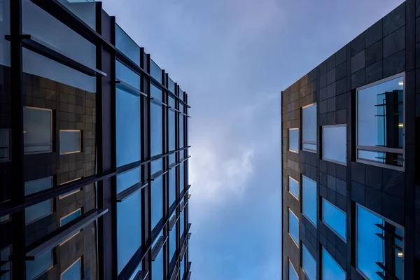 Mavi gökyüzü arka planına karşı modern bir apartmanın cephesi. Fotoğraf, güneşli bir günde öğleden sonra çekildi..