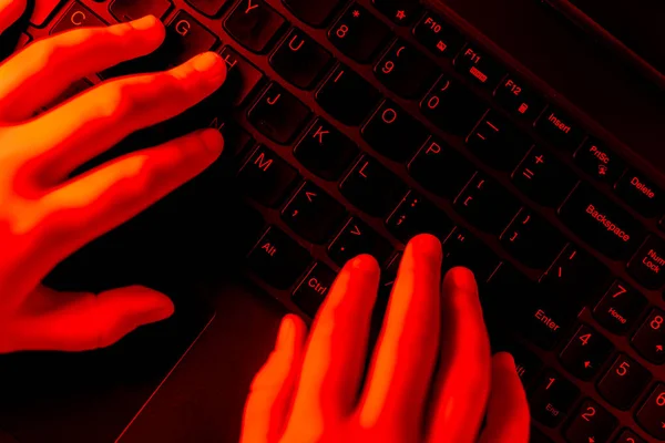 小女孩正在键盘上打字 儿童在互联网上的危险行为 用红色照亮的场景 — 图库照片