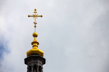 Bulutlu gökyüzüne karşı kilisenin tepesinde Ortodoks haçı. Fotoğraf bulutlu bir günün doğal ışığında çekildi.