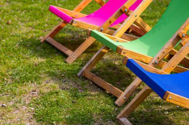 Rahatlama alanındaki katlanabilir renkli bahçe sandalyeleri. Fotoğraf güneşli bir günde çekildi. Gölgeli bir yerde nesneler