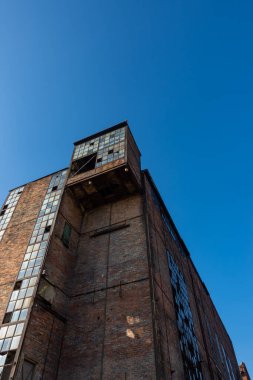 Terk edilmiş bir sanayi tesisinin kalıntıları. Mavi gökyüzünün arka planına karşı tuğla duvarlar. Fotoğraf güneşli bir günde çekildi..