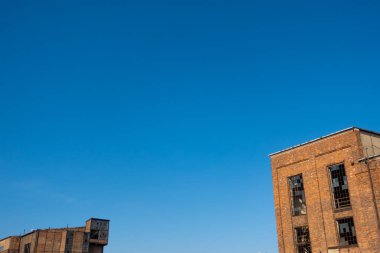 Terk edilmiş bir sanayi tesisinin kalıntıları. Mavi gökyüzünün arka planına karşı tuğla duvarlar. Fotoğraf güneşli bir günde çekildi..