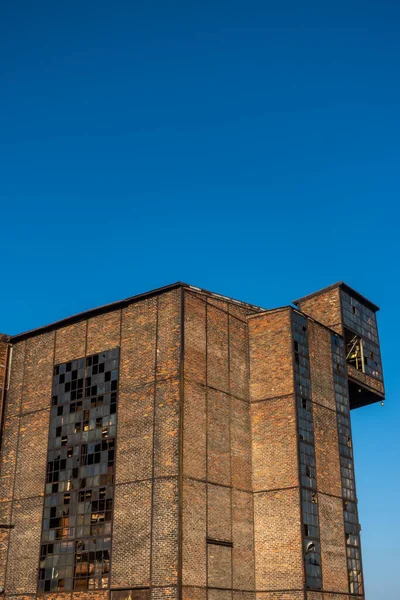 Terk edilmiş bir sanayi tesisinin kalıntıları. Mavi gökyüzünün arka planına karşı tuğla duvarlar. Fotoğraf güneşli bir günde çekildi..