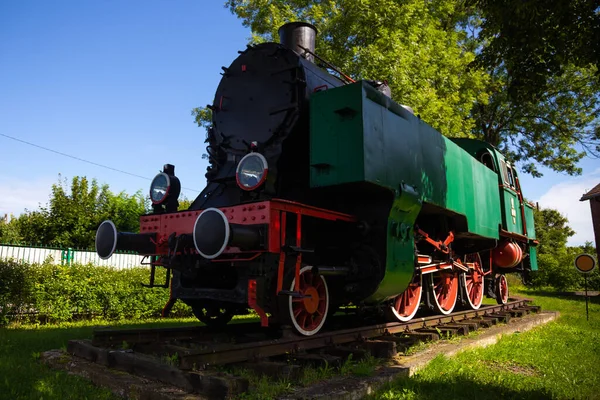 A steam locomotive standing outside of historic locomotive shed. The shot was taken in natural lighting conditions