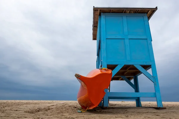 Blue Lifeguard Booth Beach Cloudy Day Orange Lifeboat Leaning Side — Fotografia de Stock