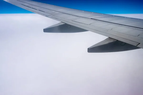 从飞机窗到机翼的景色 在云层上飞行时拍的照片 是一片由云彩构成的可见的地平线 — 图库照片