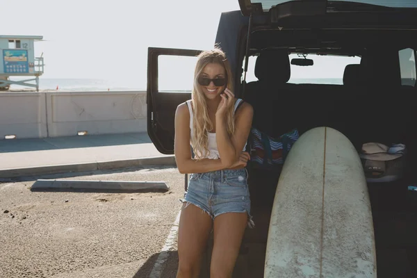 สาวนักโต้คลื่นนั่งที่รถพร้อมกระดานโต้คลื่น ในหนัง แคลิฟอร์เนีย — ภาพถ่ายสต็อก