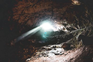 Photo through a cave. It is magical how the light seems to enter the cave in the form of a sunbeam.