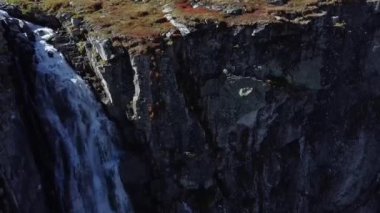Weissee buzulu bölgesinde, Avusturya 'nın Salzburg kentinde Hohe Tauern Ulusal Parkı' nda, heybetli bir şelaleye yakın uçan bir insansız hava aracı.