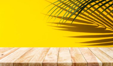 Selective focus.Nature product display with wood table counter on palm leaf in vibrant color background.For key visual layout