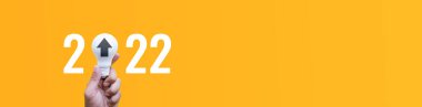 2022 number with person hand holding lightbulb on pastel color background.Ideas creativity,inspiration,concepts.for long banner size