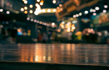 Bulanık kafedeki boş ahşap masa üstü koyu arka planda / seçici odak. Montaj ürünü görüntüleme için