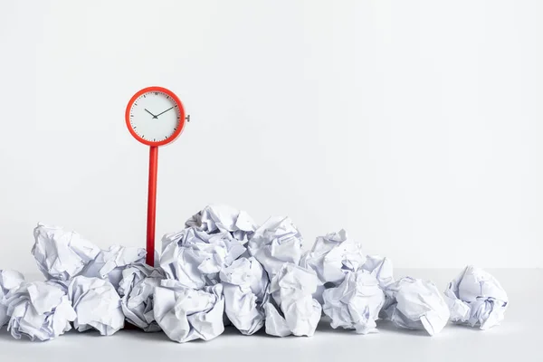 Timing and thinking idea with paper crumpled ball and red clock.business performance