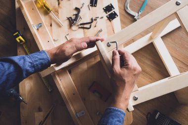 İnsan ahşap mobilya montajı, tornavida araçlarıyla ev onarımı veya onarımı. Modern yaşam kavramları