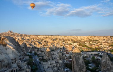 Vadinin üzerinde uçan renkli sıcak hava balonları ve Goreme, Kapadokya, Türkiye yakınlarında peri bacaları olan kaya oluşumları