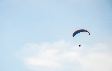 Karpatya dağlarında sisli gökyüzünde uçan paraglider silueti. Popüler turist ekstrem spor aktivitesi