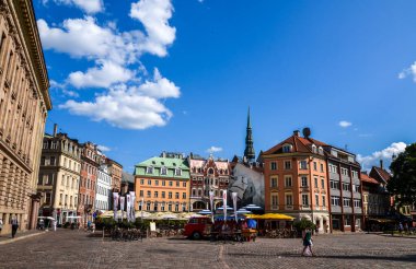 RIGA, LATVIA - 26 Temmuz 2014: Güneşli bir yaz gününde Old Riga 'nın göbeğindeki renkli binalar arasında açık hava restoranları bulunan Cobbled Dome Meydanı