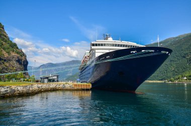 Flam limanında büyük bir yolcu gemisi. Arka planda fiyortları olan güzel bir manzara. Sognefjord, Norveç. İstikamet ve seyahat.