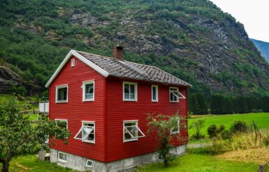 Geleneksel Norveç kırmızı-beyaz ahşap evi Flam 'deki flordun arka planında