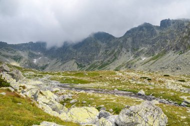 Slovakya, High Tatras 'ta bulutlu gökyüzünün altında dağların güzel, keskin tepeleri.