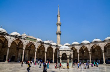 İSTANBUL, TURKEY - 28 Mayıs 2015: Sultan Ahmed Mavi Cami Bahçesi ve Minare. Büyük sarayda yürüyen turistlerin etrafında bir çeşme ve atari salonu bulunuyor.