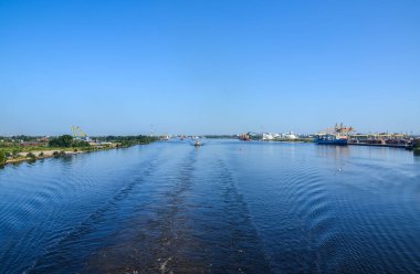 Daugava nehrinde konteynır gemileri ve vinçlerle kargo taşımacılığının sanayi manzarası. Riga, Letonya