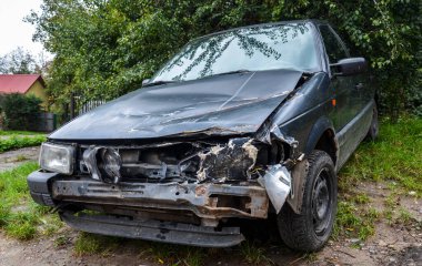 Çarpışan bir farın yakın çekimi ve eski bir arabanın ön köşesi. Alkollü araç kullanmanın etkileri. Trafik kazası. Parçalanmış araç.