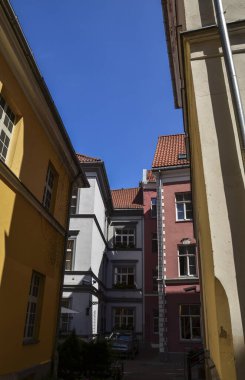 Eski Riga, Letonya 'da ortaçağ caddesinde kiremitli çatısı olan güzel renkli binaların manzarası