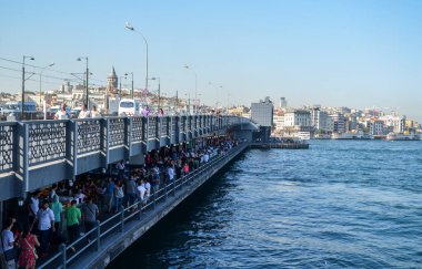 İSTANBUL - 12 Ağustos 2015: İstanbul, Türkiye 'nin tarihi merkezindeki Galata Köprüsü' nde yürüyen turist kalabalığı