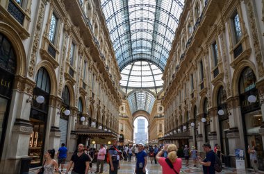 MILAN, ITALY - 25 Haziran 2017: Dünyanın en büyük alışveriş merkezlerinden biri olan Milano, İtalya 'nın merkezindeki Galleria Vittorio Emanuele II' de yürüyen insanlar